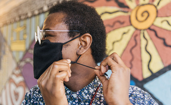 Person adjusting the adjustable ear loops/lanyard of the V4 Mask.